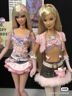 two barbie dolls standing next to each other