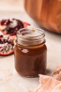 a jar of peanut butter next to some pomegranates