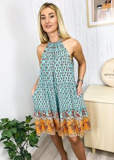 The Emes Shop dress is detailed with a classic halter neck line. Features a boho print. tiered design. tie ribbon back. shift dress silhouette. and knee length. Pair it with a straw hat and sandals for a stunning look.MATERIALS: 71-80% CottonMEASUREMENTS: Product length is 31-34" in 4-6-Small | Waist: 40 in | Chest: 40 in 6-8-Medium | Waist: 41-28 in | Chest: 42 in 8-10-Large | Waist: 44 in | Chest: 44 in 10-12-X-Large | Waist: 46 in | Chest: 47 in MEASUREMENTS: Product length is 81-87 cm 4-6-Small | Waist: 102 cm | Chest: 104 cm 6-8-Medium | Waist: 106 cm | Chest: 108 cm 8-10-Large | Waist: 112 cm | Chest: 114 cm 10-12-X-Large | Waist: 118 cm | Chest: 120 cm Spring Vacation Halter Dress With Tiered Design, Spring Tiered Halter Dress For Vacation, Tiered Halter Dress For Beach, Bohemian Tiered Sundress For Garden Party, Tiered Boho Dress For Beach In Spring, Tiered Boho Beach Dress For Spring, Tiered Boho Dress For Beach And Spring, Knee-length Halter Sundress For Vacation, Bohemian Tiered Sundress For Beach Season