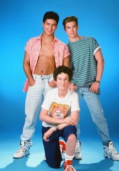 three young men posing for a photo in front of a blue background