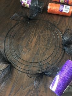 several different types of yarn and scissors on a wooden table with wire mesh around it