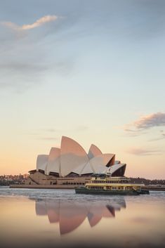 the sydney opera house in australia is reflected in the water at sunset or dawn,