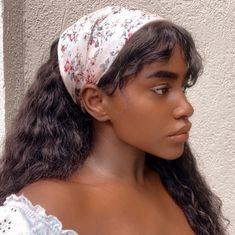 a woman with long hair wearing a white headband and looking off to the side