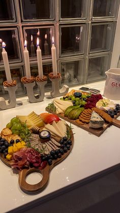 two trays filled with different types of cheese and meat on top of a counter