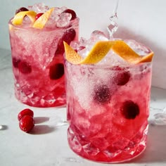 two glasses filled with ice and garnished fruit