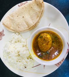 a white plate topped with rice and meat next to a pita