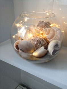 a fish bowl filled with sea shells and lights