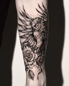 a man's arm with a bird and roses tattoo on the left side of his leg