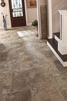 an entryway with stairs and tile flooring next to a door in a house