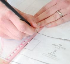 a person is measuring the length of a piece of paper