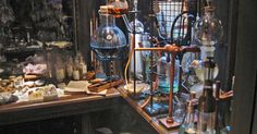 an assortment of glass bottles and other items on a shelf in a room with dark lighting