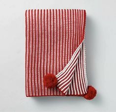 a red and white striped towel with a pom - pom on the end