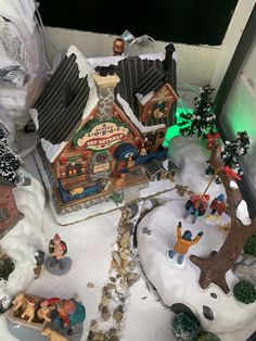 a small christmas village is shown in the snow