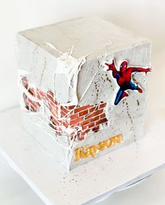 a spiderman cake on top of a white plate