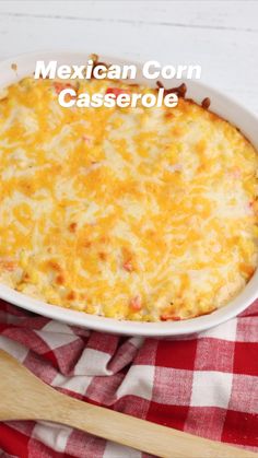 mexican corn casserole in a white dish on a red and white checkered cloth