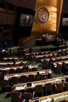 an empty room with several people sitting in chairs