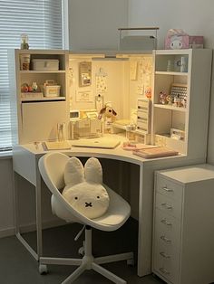 a desk with a stuffed animal in the middle and shelves on both sides that are open