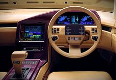 an interior view of a car with the steering wheel and dash board showing, it appears to be beige