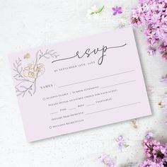 a pink and gold wedding rsp card with flowers on the table next to it