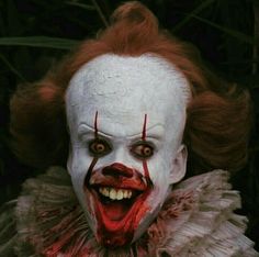 a creepy clown with red hair and white makeup