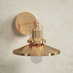 an antique brass wall light on a white wall