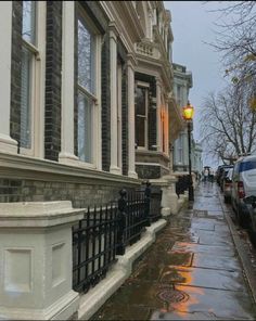 a wet sidewalk with cars parked on it