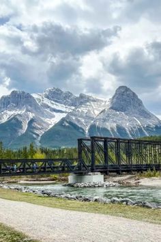 a bridge over a river with mountains in the background