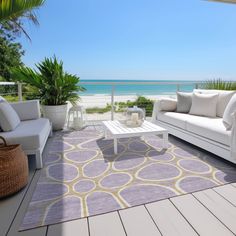 a living room with white furniture and an ocean view