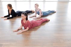 three women are doing yoga on the floor