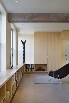 an empty room with bookshelves and a chair in the middle, next to a book shelf