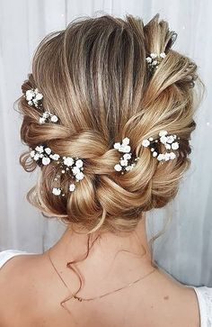 the back of a woman's head, with flowers in her hair and an upside down bun