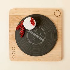 a record player with a piece of cake on it's side sitting on a wooden board