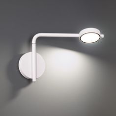 a white wall mounted light on a gray wall