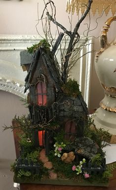 a small house made out of wood and moss