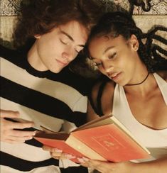 two people laying down reading a book together