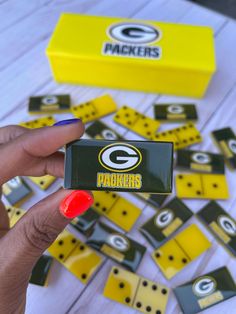 the green bay packers dominos are being held up by a woman's hand