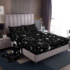 a bed with black and white stars and moon designs on it