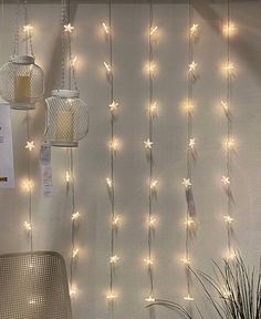 there are lights hanging from the ceiling in front of a curtain that is covered with string lights