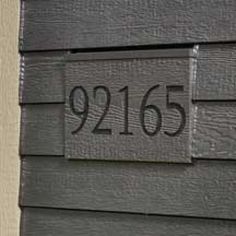 a close up of a house number sign on the side of a building with numbers painted on it