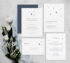 the wedding stationery is laid out next to some flowers