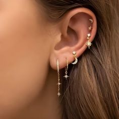 a woman's ear with stars and moon earrings