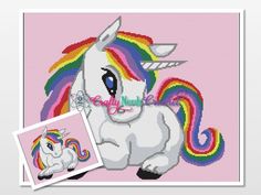 a cross stitch unicorn with a rainbow mane on it's head next to a pink background