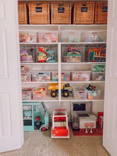 an organized playroom with toys and baskets on the shelves in front of it is shown