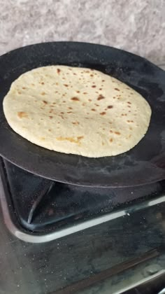 an uncooked tortilla sitting on top of a stove in the oven