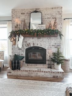 a living room filled with furniture and a fire place covered in greenery next to a window