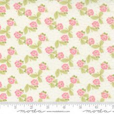 a white and pink flowered fabric with green leaves on the bottom, in front of a ruler