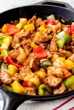 a skillet filled with meat, peppers and onions