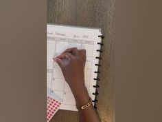 a woman's hand on top of a planner