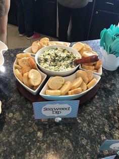 a table topped with bowls filled with dips and crackers