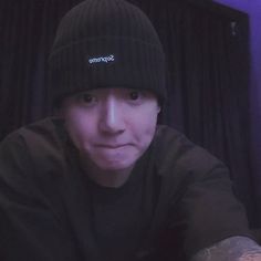 a man wearing a black beanie and looking at the camera